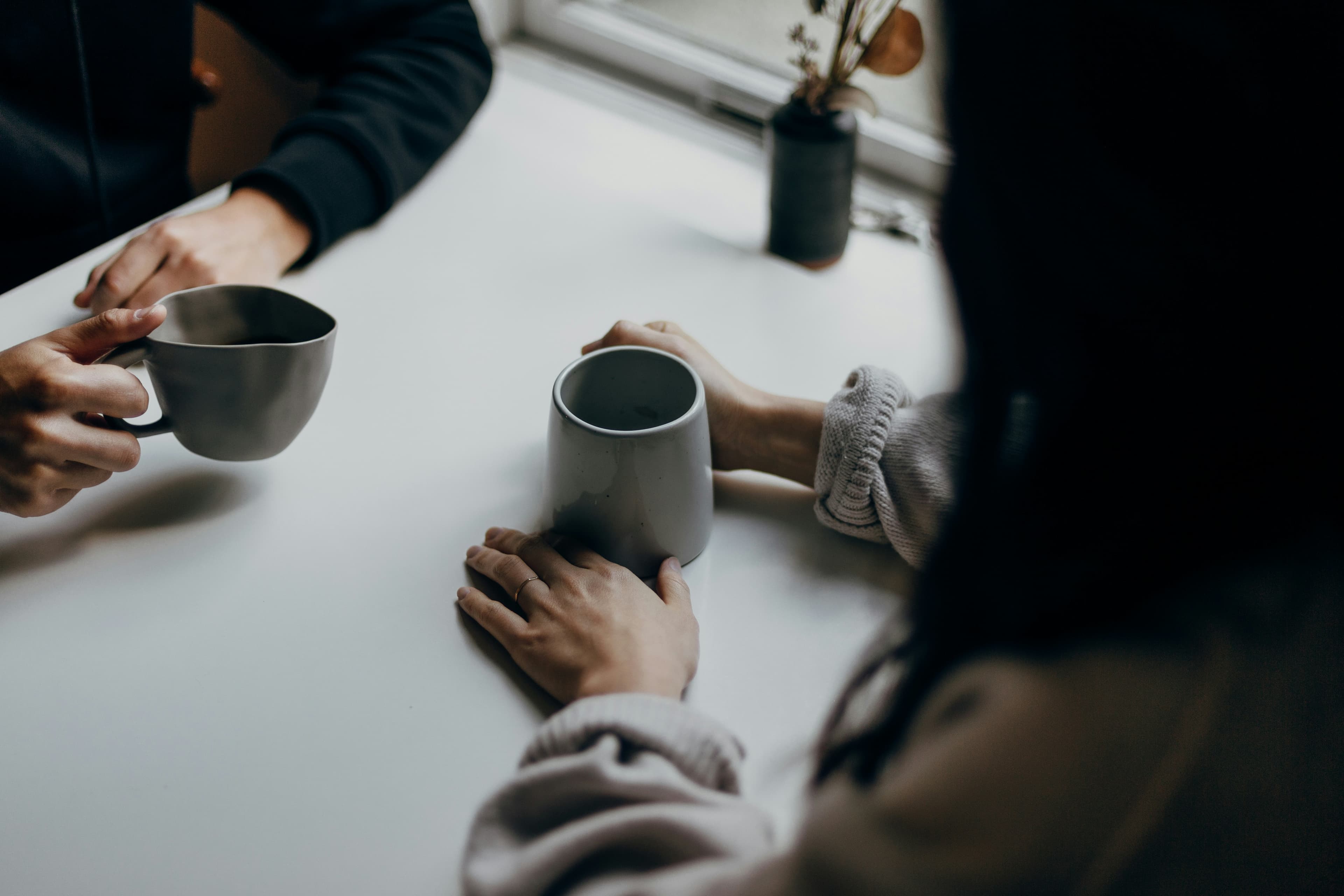Two people having a conversation over coffee